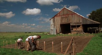 Movie still from “Secondhand Lions” (2003), directed by Tim McCanlies – A man and a woman working in a farm field; Extreme Wide shot, High angle
