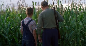 Movie still from “Secondhand Lions” (2003), directed by Tim McCanlies – A man and a young boy standing next to each other in a corn field; Medium shot, Over the shoulder angle