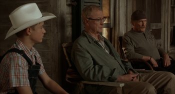 Movie still from “Secondhand Lions” (2003), directed by Tim McCanlies – A man sitting in a chair next to two other men; Medium shot, Over the shoulder angle