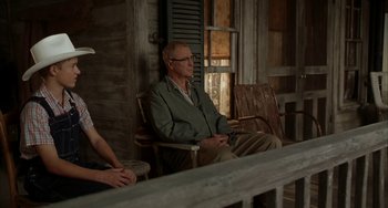 Movie still from “Secondhand Lions” (2003), directed by Tim McCanlies – An older man sitting on a chair in front of a window; Medium shot, Over the shoulder angle