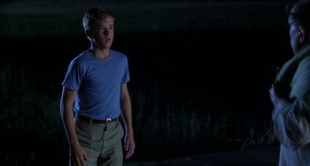 Movie still from “Secondhand Lions” (2003), directed by Tim McCanlies – A young man standing in front of a body of water at night; Medium shot, Low angle