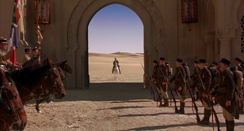 Movie still from “Secondhand Lions” (2003), directed by Tim McCanlies – A group of men on horseback standing in front of an archway in the desert; Extreme Wide shot, Over the shoulder angle