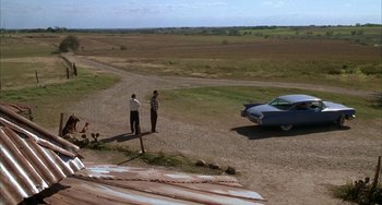 Movie still from “Secondhand Lions” (2003), directed by Tim McCanlies – Two men standing on the side of a road near a car; Extreme Wide shot, High angle