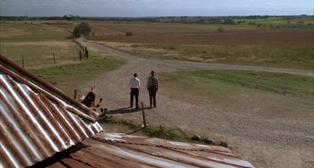 Movie still from “Secondhand Lions” (2003), directed by Tim McCanlies – Two men standing on a dirt road near a field; Extreme Wide shot, High angle