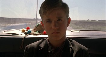 Movie still from “Secondhand Lions” (2003), directed by Tim McCanlies – A young boy in a suit looking at the camera; Close Up shot, Low angle