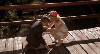 Movie still from “Secondhand Lions” (2003), directed by Tim McCanlies – A boy and a girl sitting on a wooden bridge; Wide shot, High angle