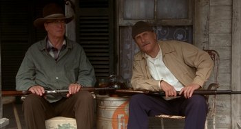 Movie still from “Secondhand Lions” (2003), directed by Tim McCanlies – Two men sitting next to each other holding guns; Medium shot, Low angle