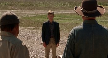 Movie still from “Secondhand Lions” (2003), directed by Tim McCanlies – A young man standing in front of a group of people; Medium shot, Over the shoulder angle