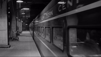 Movie still from “Seconds” (1966), directed by John Frankenheimer – A black - and - white photo of a train at a train station; Wide shot, High angle
