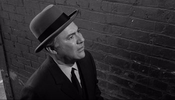 Movie still from “Seconds” (1966), directed by John Frankenheimer – A black and white photo of a man in a suit and a hat; Close Up shot, Low angle
