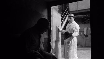 Movie still from “Seconds” (1966), directed by John Frankenheimer – A black and white photo of a man painting a wall; Medium shot, Low angle