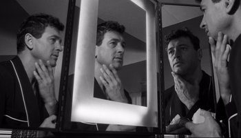 Movie still from “Seconds” (1966), directed by John Frankenheimer – A black and white photo of a man looking at himself in the mirror; Close Up shot, Low angle