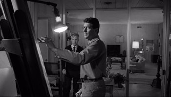 Movie still from “Seconds” (1966), directed by John Frankenheimer – A man standing in front of an easel in a room; Medium shot, Low angle