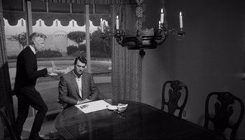 Movie still from “Seconds” (1966), directed by John Frankenheimer – A black and white photo of a man sitting at a dining room table; Wide shot, High angle