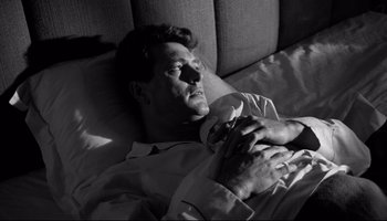 Movie still from “Seconds” (1966), directed by John Frankenheimer – A black and white photo of a man laying in bed; Close Up shot, High angle