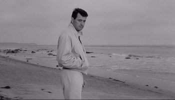 Movie still from “Seconds” (1966), directed by John Frankenheimer – A black and white photo of a man standing on the beach; Medium shot, Low angle