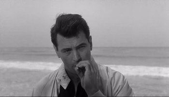 Movie still from “Seconds” (1966), directed by John Frankenheimer – A black - and - white photo of a man on the beach; Close Up shot, Low angle