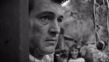 Movie still from “Seconds” (1966), directed by John Frankenheimer – A black - and - white photo of a man looking at the camera; Close Up shot, Low angle