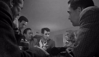 Movie still from “Seconds” (1966), directed by John Frankenheimer – A black and white photo of a group of men and a woman; Medium shot, Low angle