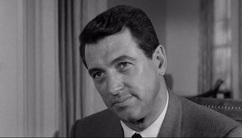 Movie still from “Seconds” (1966), directed by John Frankenheimer – Black and white photograph of a man wearing a suit and tie; Close Up shot, Over the shoulder angle
