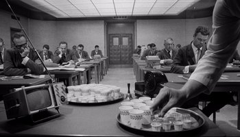 Movie still from “Seconds” (1966), directed by John Frankenheimer – A black and white photo of people sitting at tables; Wide shot, High angle