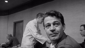 Movie still from “Seconds” (1966), directed by John Frankenheimer – A man is looking at the camera while another man looks at the camera; Close Up shot, Low angle