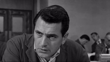 Movie still from “Seconds” (1966), directed by John Frankenheimer – A black - and - white photo of a man looking at the camera; Close Up shot, Over the shoulder angle