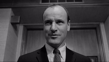 Movie still from “Seconds” (1966), directed by John Frankenheimer – Black and white photograph of a man in a suit and tie; Close Up shot, Low angle