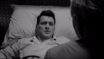 Movie still from “Seconds” (1966), directed by John Frankenheimer – A black and white photo of a man in a hospital bed; Medium shot, Over the shoulder angle