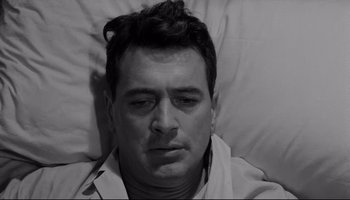 Movie still from “Seconds” (1966), directed by John Frankenheimer – A black and white photo of a man in bed; Close Up shot, Overhead angle