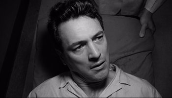 Movie still from “Seconds” (1966), directed by John Frankenheimer – Black and white photograph of a man looking at the camera; Close Up shot, High angle