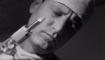 Movie still from “Seconds” (1966), directed by John Frankenheimer – A person wearing a surgical mask; Close Up shot, Low angle