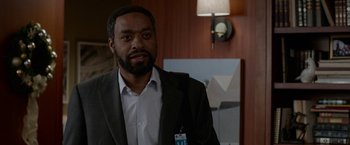 Movie still from “Secret in Their Eyes” (2015), directed by Billy Ray – A man in a suit standing in front of a lamp; Close Up shot, Over the shoulder angle