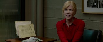 Movie still from “Secret in Their Eyes” (2015), directed by Billy Ray – A woman sitting at a table in a room; Close Up shot, Over the shoulder angle