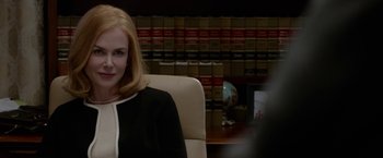 Movie still from “Secret in Their Eyes” (2015), directed by Billy Ray – A woman sitting in a chair in front of a bookshelf; Close Up shot, Over the shoulder angle