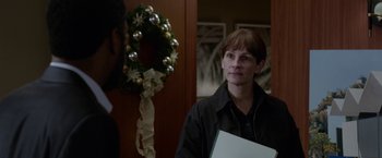 Movie still from “Secret in Their Eyes” (2015), directed by Billy Ray – A woman standing in front of a christmas wreath; Close Up shot, Over the shoulder angle