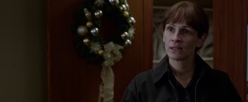 Movie still from “Secret in Their Eyes” (2015), directed by Billy Ray – A woman standing in front of a christmas wreath; Close Up shot, Over the shoulder angle
