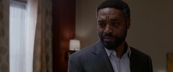 Movie still from “Secret in Their Eyes” (2015), directed by Billy Ray – A person wearing a suit and tie; Close Up shot, Over the shoulder angle