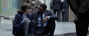 Movie still from “Secret in Their Eyes” (2015), directed by Billy Ray – A man and a woman sitting on the sidewalk; Medium shot, Over the shoulder angle