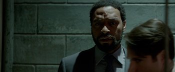 Movie still from “Secret in Their Eyes” (2015), directed by Billy Ray – A man in a suit and tie looking at the camera; Close Up shot, Low angle