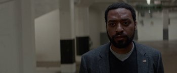 Movie still from “Secret in Their Eyes” (2015), directed by Billy Ray – A man in a gray jacket is looking at the camera; Close Up shot, Low angle