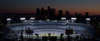 Movie still from “Secret in Their Eyes” (2015), directed by Billy Ray – A view of a baseball stadium at night with the city skyline in the background; Extreme Wide shot, High angle
