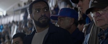 Movie still from “Secret in Their Eyes” (2015), directed by Billy Ray – A man and a man in a baseball cap looking at each other; Close Up shot, Low angle