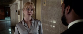 Movie still from “Secret in Their Eyes” (2015), directed by Billy Ray – A woman standing in front of a wall in a building; Close Up shot, Over the shoulder angle