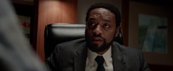 Movie still from “Secret in Their Eyes” (2015), directed by Billy Ray – A man in a suit and tie sitting in a chair; Close Up shot, Low angle