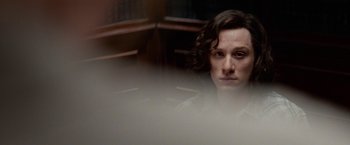 Movie still from “Secret in Their Eyes” (2015), directed by Billy Ray – A man with long hair is sitting in a room; Close Up shot, Over the shoulder angle