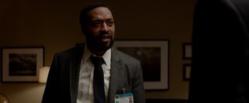 Movie still from “Secret in Their Eyes” (2015), directed by Billy Ray – A man in a suit and tie with a badge on his lapel; Close Up shot, Over the shoulder angle