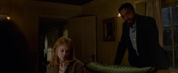 Movie still from “Secret in Their Eyes” (2015), directed by Billy Ray – A man and a woman sitting in a living room next to each other; Medium shot, Over the shoulder angle