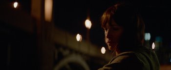 Movie still from “Secret in Their Eyes” (2015), directed by Billy Ray – A woman with red hair is standing in the dark; Close Up shot, Over the shoulder angle