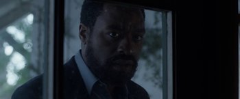 Movie still from “Secret in Their Eyes” (2015), directed by Billy Ray – A person with a beard looking at the camera; Close Up shot, Low angle